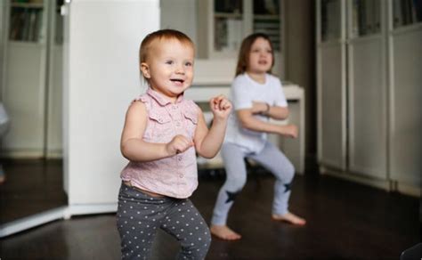 tėvai ir vaikas šoka pagal muziką