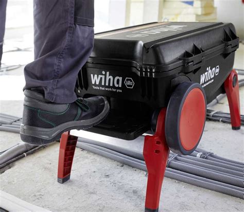 Žmogus su lagaminu, sėdintis prie inkstų dializės aparato