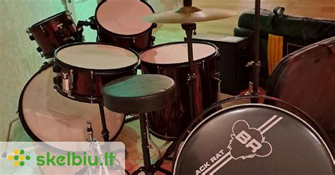 vaikas rūpestingai valo savo būgnų komplektą