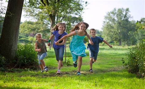 Vaikai, žaidžiantys lauke, aktyviai judantys ir bendraujantys