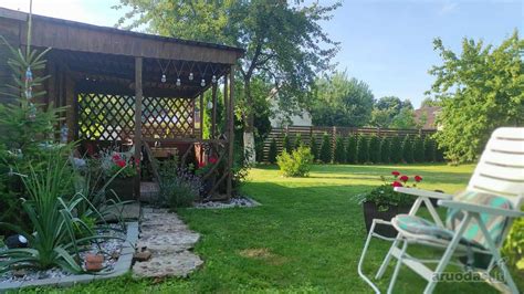 Vežimėlis dvinukams, kuriame vaikai sėdi vienas šalia kito