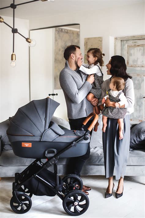 Šeima su dvynukų vežimėliu parke