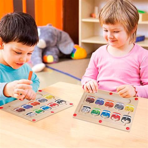 Vaikas rūšiuoja spalvotus kamštukus ant paveiksliuko