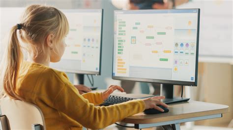 mokytojas dirba su vaikais prie kompiuterio