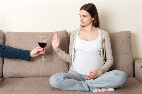 Nėščia moteris su alkoholio simboliu
