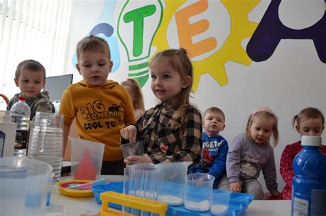 vaikų grupė, atliekanti eksperimentus su vandeniu