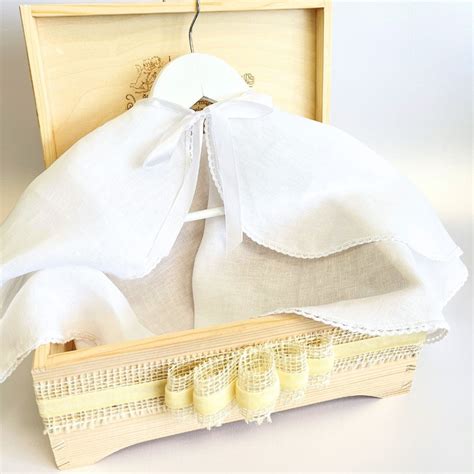 Krikšto apeigų atributai: kryžius, baltas drabužis