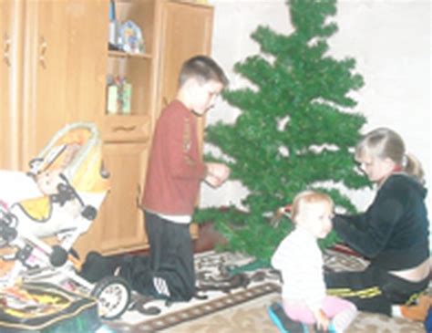 vaikai puošia kalėdų eglutę