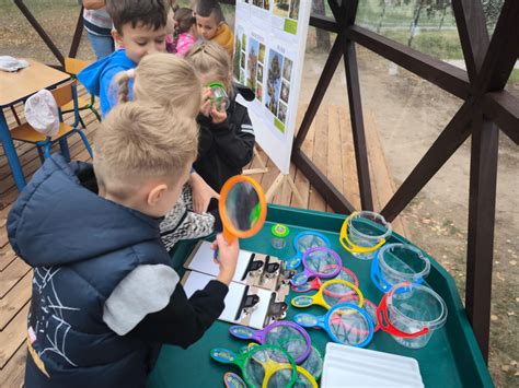vaikai tiria augalus darželio edukacinėje erdvėje