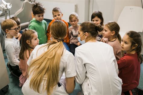 vaikai su dantų maketu ir šepetėliais