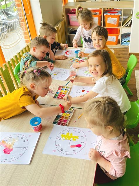 mokytojas padeda vaikui piešti