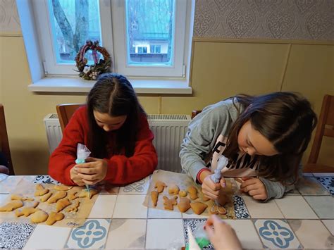 vaikai dekoruoja kalėdinius meduolius su spalvotu glajumi