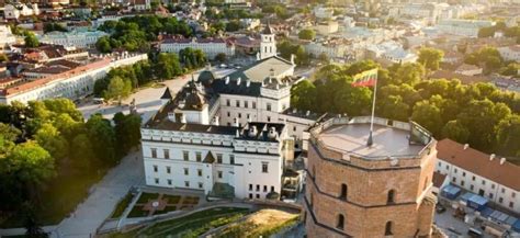 Poros, laikomos už rankų ir žiūrinčios į saulėlydį