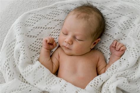 Tėvai su naujagimiu fotosesijos metu