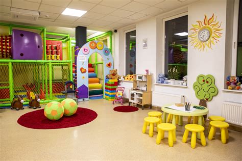 Erdvus, šviesus vaikų darželio žaidimų kambarys su moderniais baldais