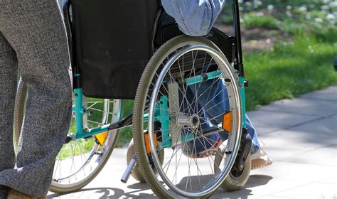 vaikas neįgaliojo vežimėlyje su tėvais