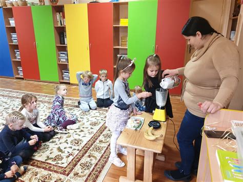 Pedagogai žaidžiantys su vaikais lauke