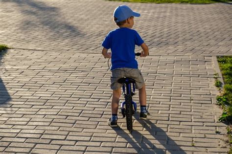 vaikas važiuoja pirmuoju pedalų dviračiu
