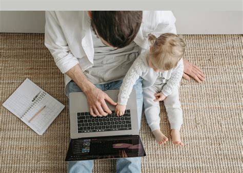 Darbuotojas su vaiku dirba kompiuteriu