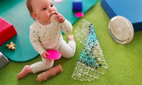 Kūdikis žaidžia su lavinamuoju žaislu