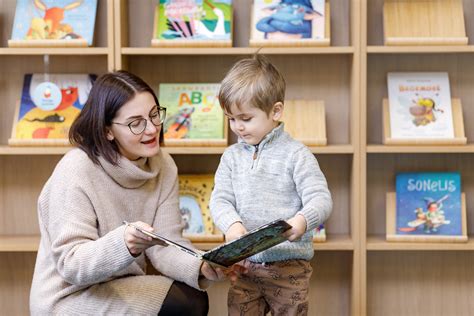 Vaikai skaito knygas bibliotekoje