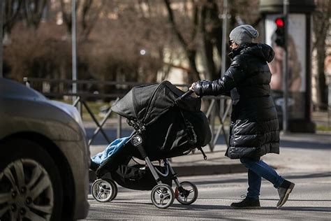 Nuotrauka, vaizduojanti jauną šeimą su kūdikiu, simbolizuojanti motinystės ir vaiko priežiūros išmokų svarbą