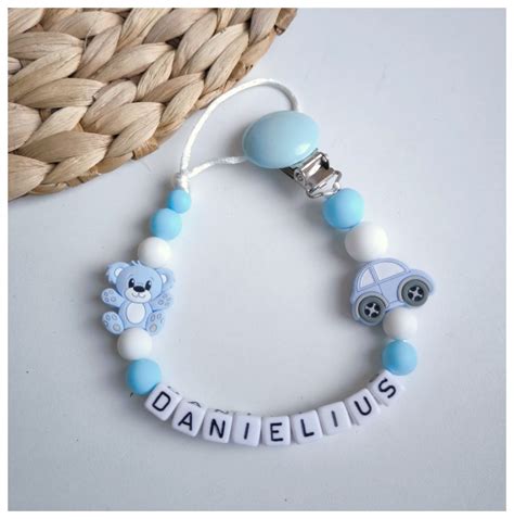 Vardinis čiulptuko laikiklis su karoliukais ir automobilio bei meškiuko figūrėlėmis