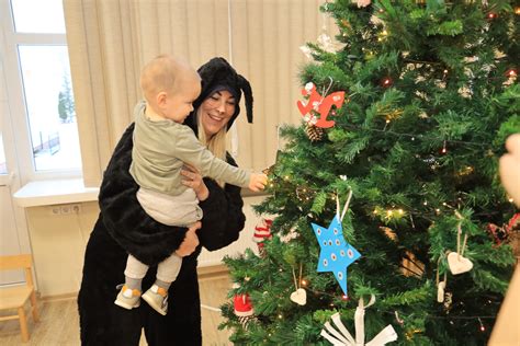 šeima puošia kalėdinę eglutę