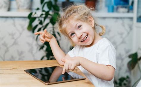 Vaikai, tyrinėjantys gamtą su planšetiniu kompiuteriu lauke