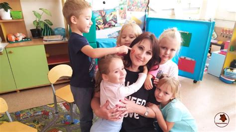 Darželio auklėtoja kalbasi su vaikais