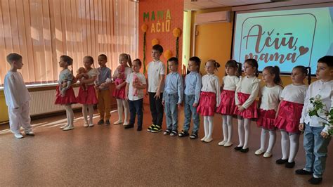 Vaikų grupė dainuoja ir šoka scenoje