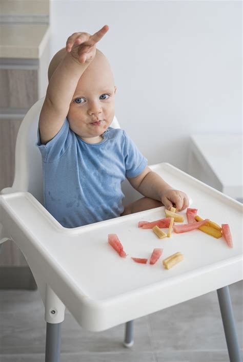 kūdikis bando valgyti šaukšteliu