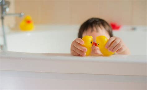 Vaikas maudosi vonioje su žaislais