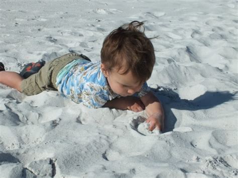 vaikas žaidžiantis smėlio dėžėje