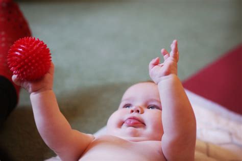 kūdikis ant pilvo daro atsispaudimus, siekdamas žaislo