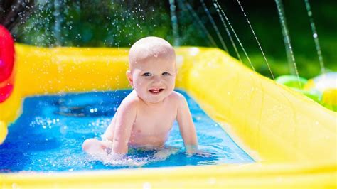 kūdikis baseine žaidžia su vandeniu