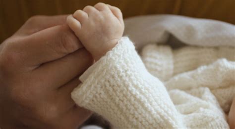 Naujagimis kūdikis kostiumu ir portfeliu