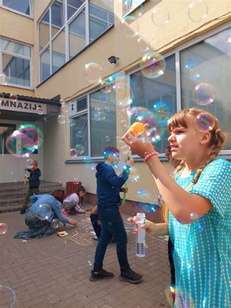 vaikai pūčia muilo burbulus šaltyje
