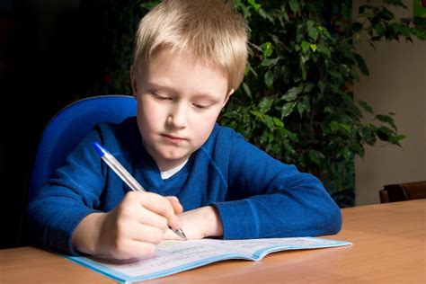 vaikas daro namų darbus su pertraukomis