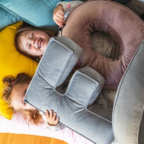 Įvairių spalvų ir dydžių pagalvėlės vaikų kambariui