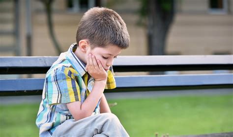 Vaikas konstruoja metalinį modelį, susikaupęs