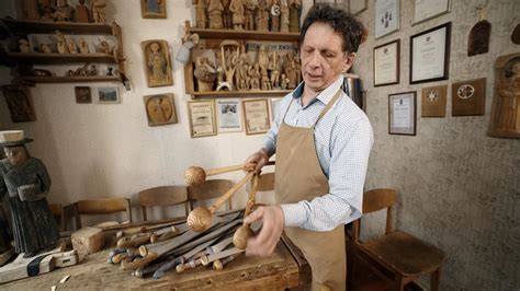 Jaunas vyras skulptorius dirbtuvėje su medžio ruošiniais