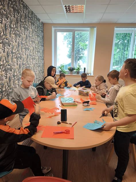 Vaikų grupė, žaidžianti lauke prie dienos centro