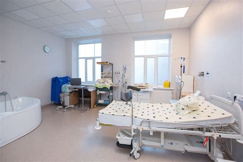 Akušerė stebi moterį gimdymo vonioje